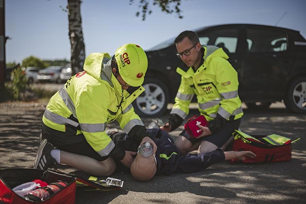 Två civila insatspersoner övar på en docka